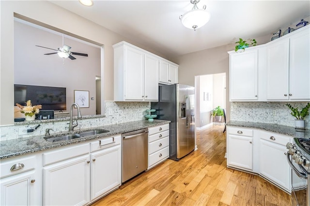 kitchen with white cabinetry, ceiling fan, appliances with stainless steel finishes, decorative backsplash, and sink