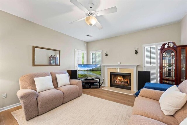 3652 Morning Creek Ct, Suwanee, GA 30024 - living area featuring wood finished floors, a warm lit fireplace, ceiling fan, and baseboards