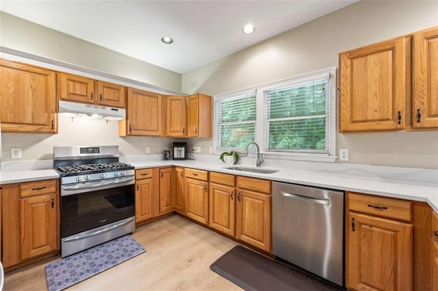 3652 Morning Creek Ct, Suwanee, GA 30024 - kitchen featuring appliances with stainless steel finishes, a sink, under cabinet range hood, light wood-type flooring, and light countertops