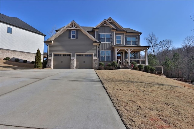 craftsman inspired home with a garage, a front lawn, and covered porch