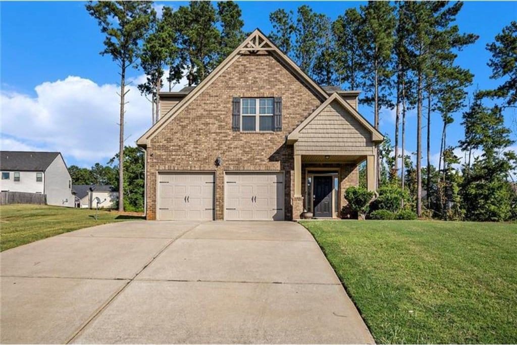 71 Pulaski Ave, Hampton, GA 30228 - craftsman house with a front lawn, concrete driveway, brick siding, and a garage