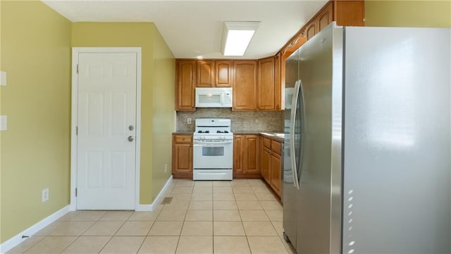 kitchen featuring white appliances, baseboards, brown cabinetry, backsplash, and light tile patterned flooring