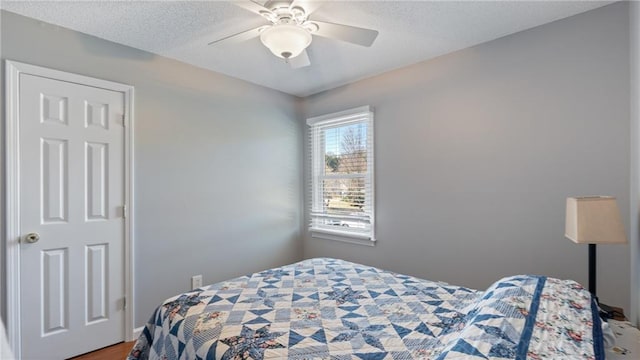 bedroom with ceiling fan and a textured ceiling