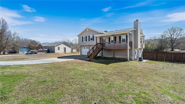 view of front of property featuring a garage, fence, stairs, concrete driveway, and a front lawn