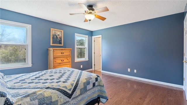 bedroom with wood finished floors, a ceiling fan, and baseboards