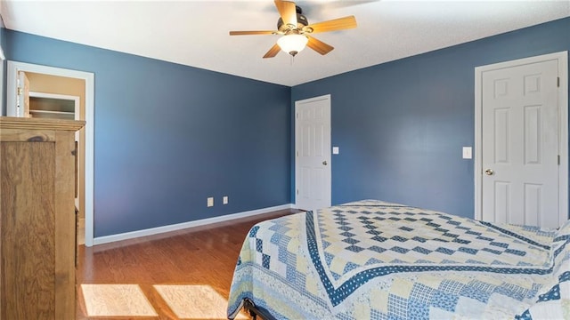 bedroom with ceiling fan, baseboards, and wood finished floors