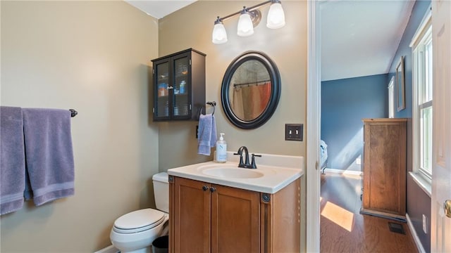 bathroom featuring visible vents, vanity, toilet, and wood finished floors