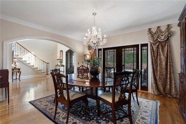 2160 Bradley Trl, Cumming, GA 30041 - dining room featuring a chandelier, arched walkways, french doors, ornamental molding, and stairs