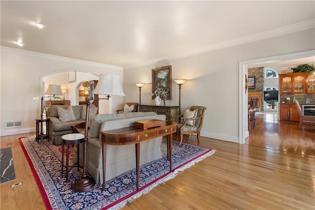 2160 Bradley Trl, Cumming, GA 30041 - living area with ornamental molding, light wood-type flooring, baseboards, and arched walkways