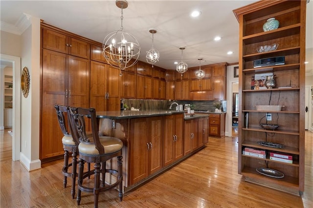 2160 Bradley Trl, Cumming, GA 30041 - kitchen with open shelves, ornamental molding, light wood-type flooring, brown cabinetry, and a chandelier