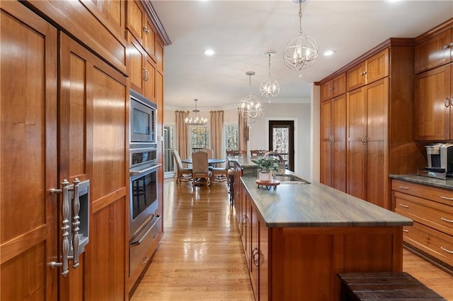 2160 Bradley Trl, Cumming, GA 30041 - kitchen with brown cabinetry, a chandelier, built in appliances, crown molding, and a sink