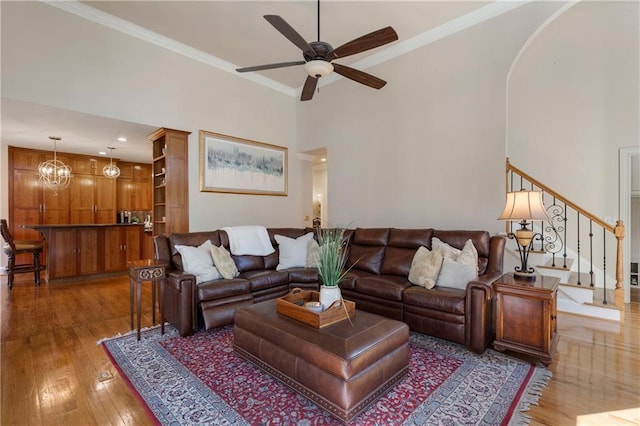 2160 Bradley Trl, Cumming, GA 30041 - living room with light wood-style floors, a ceiling fan, stairs, ornamental molding, and arched walkways