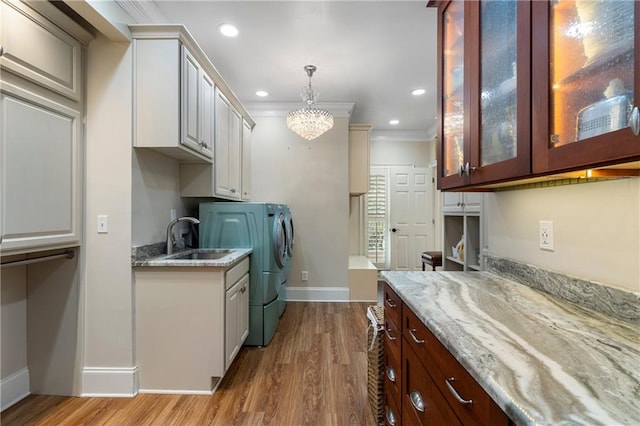 2160 Bradley Trl, Cumming, GA 30041 - washroom featuring washer and clothes dryer, baseboards, light wood finished floors, ornamental molding, and cabinet space