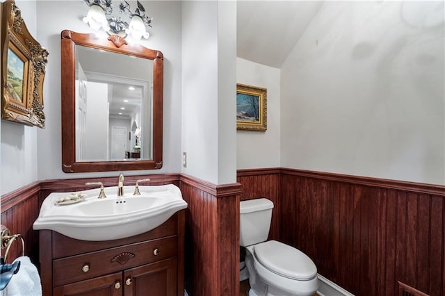 2160 Bradley Trl, Cumming, GA 30041 - half bath with a wainscoted wall, toilet, vanity, and lofted ceiling