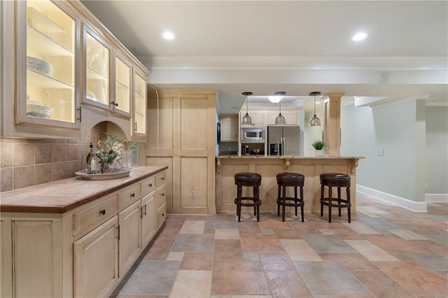 2160 Bradley Trl, Cumming, GA 30041 - kitchen featuring appliances with stainless steel finishes, a kitchen breakfast bar, crown molding, baseboards, and decorative backsplash