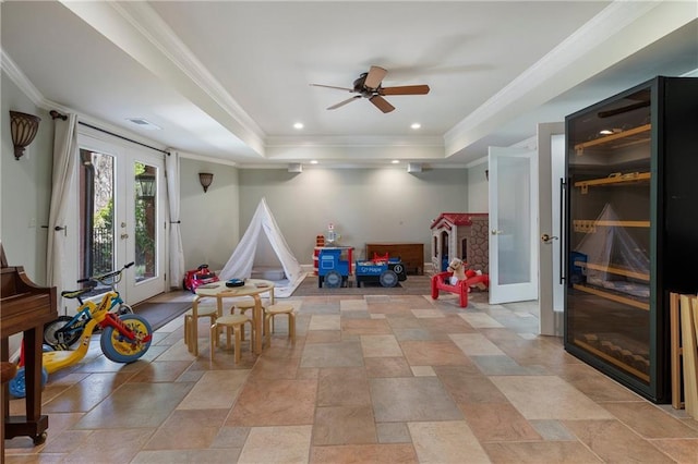 2160 Bradley Trl, Cumming, GA 30041 - playroom featuring french doors, a raised ceiling, a ceiling fan, light stone finish floors, and ornamental molding
