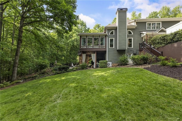 2160 Bradley Trl, Cumming, GA 30041 - back of house with a sunroom, a chimney, and a lawn