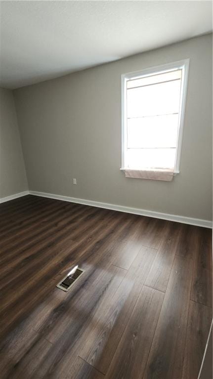 empty room with dark hardwood / wood-style flooring