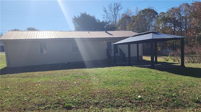 back of house with a gazebo and a lawn