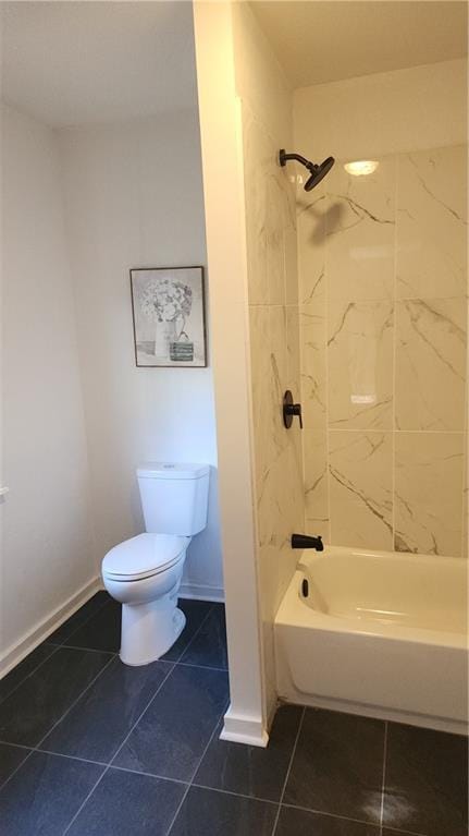 bathroom with tile patterned flooring, toilet, and tiled shower / bath