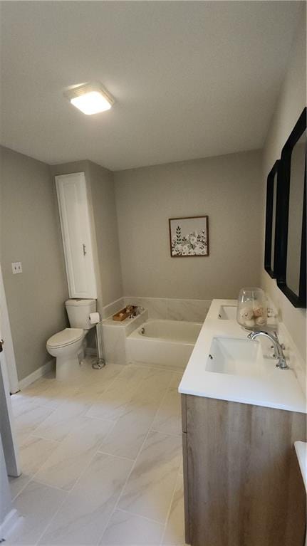 bathroom with vanity, toilet, and a tub to relax in