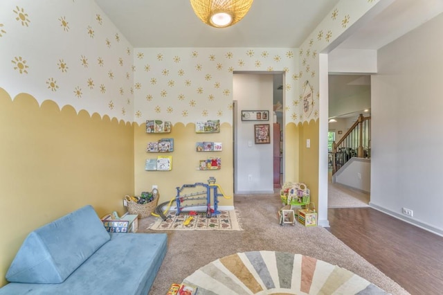 recreation room with baseboards, wallpapered walls, and wood finished floors