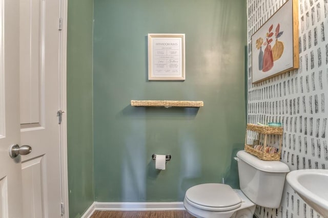 bathroom featuring toilet and baseboards