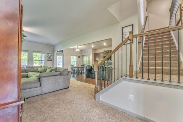 living room featuring stairs and carpet floors