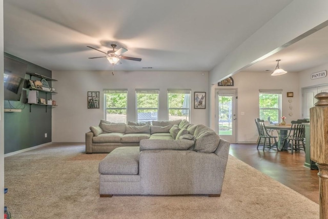living room with a ceiling fan, baseboards, and carpet flooring