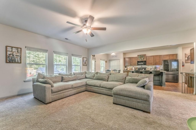 living room featuring ceiling fan and light colored carpet
