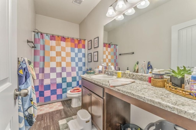 full bath featuring wood finished floors, vanity, toilet, and curtained shower