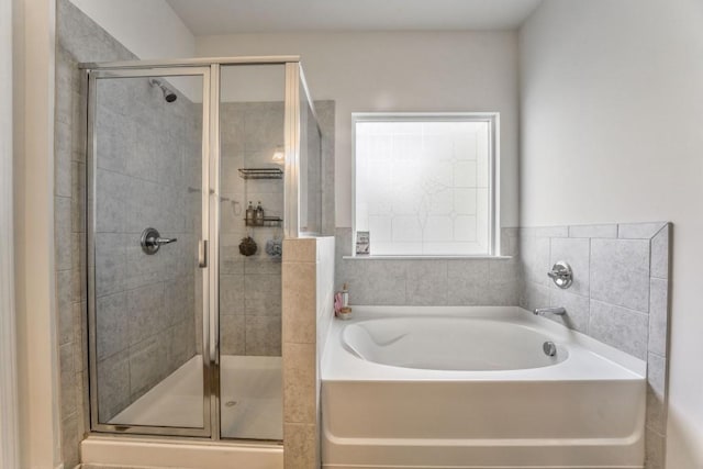 bathroom with a stall shower and a garden tub