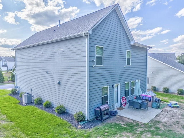 back of house with a patio, central AC unit, and a lawn