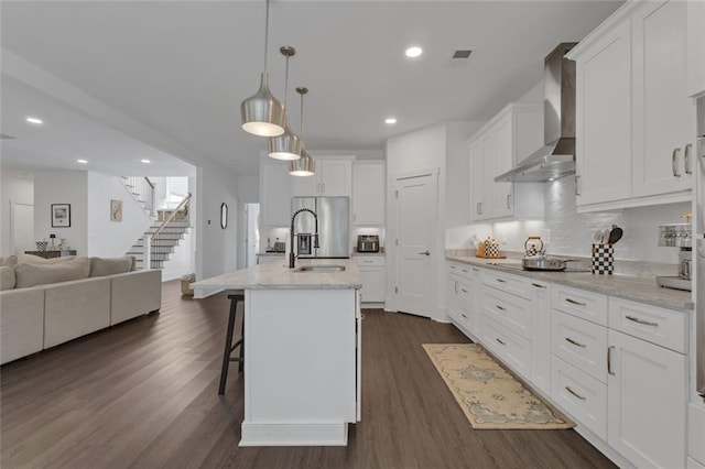 147 Wolf Creek Cv, Lagrange, GA 30240 - kitchen with wall chimney range hood, stainless steel fridge, open floor plan, white cabinetry, and dark wood-style flooring