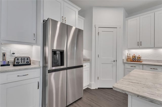 147 Wolf Creek Cv, Lagrange, GA 30240 - kitchen with stainless steel fridge, dark wood finished floors, white cabinetry, and tasteful backsplash