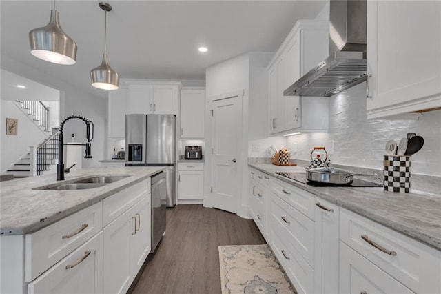147 Wolf Creek Cv, Lagrange, GA 30240 - kitchen featuring wall chimney exhaust hood, stainless steel appliances, white cabinets, dark wood-style floors, and decorative light fixtures