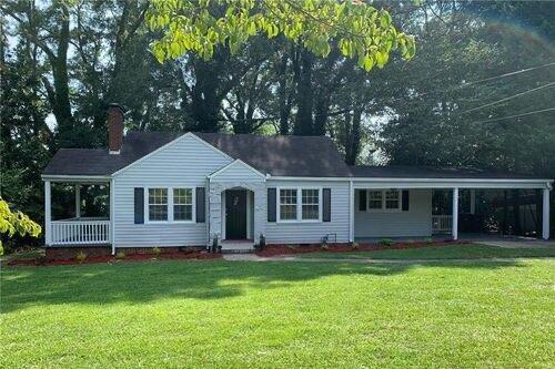 single story home featuring a front yard and a carport