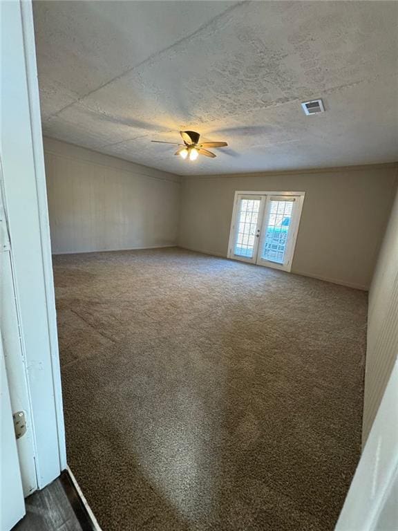 empty room with french doors, dark carpet, and ceiling fan