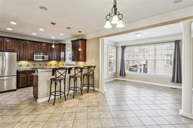 kitchen with an inviting chandelier, pendant lighting, a breakfast bar area, decorative backsplash, and appliances with stainless steel finishes