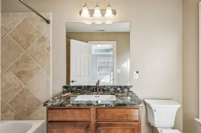 full bathroom featuring vanity, toilet, and tiled shower / bath combo