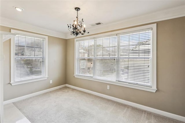 carpeted empty room with plenty of natural light, a chandelier, and ornamental molding