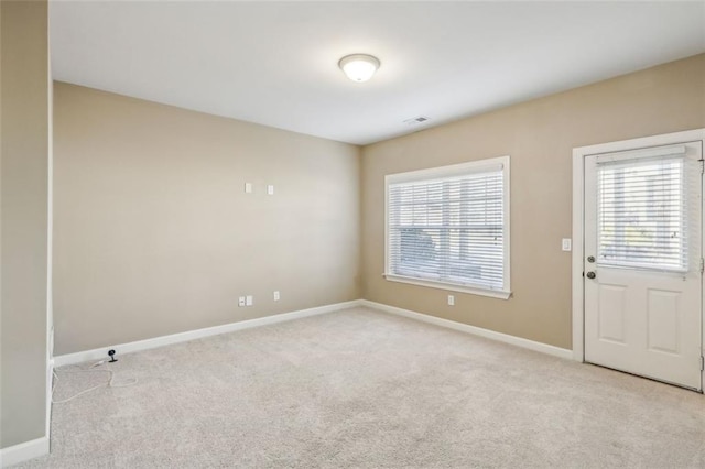 empty room featuring light carpet and plenty of natural light