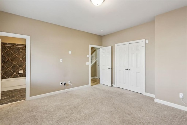 unfurnished bedroom with carpet floors, ensuite bath, and a closet