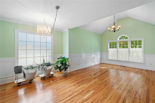 604 Greenleaf Way, Ball Ground, GA 30107 - dining space featuring a chandelier, wainscoting, wood finished floors, vaulted ceiling, and a decorative wall