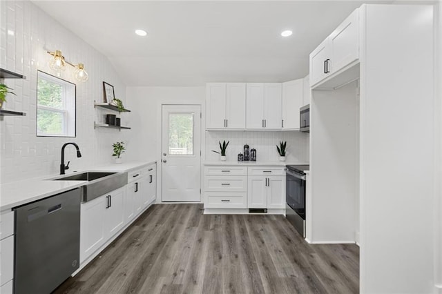 kitchen featuring hardwood / wood-style floors, backsplash, sink, white cabinetry, and stainless steel appliances