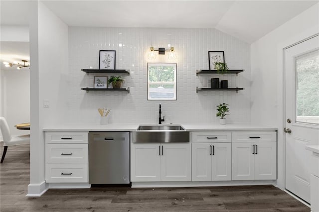 kitchen with stainless steel dishwasher, dark wood-type flooring, sink, white cabinetry, and lofted ceiling