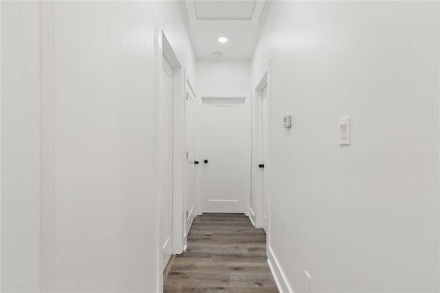 corridor with hardwood / wood-style flooring