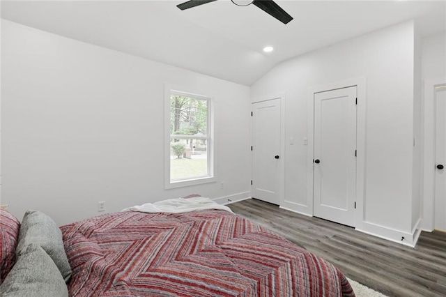 bedroom featuring dark hardwood / wood-style floors, vaulted ceiling, and ceiling fan