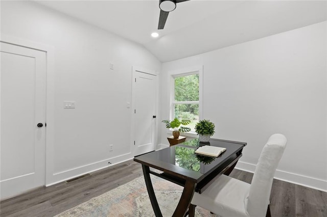 office space featuring dark hardwood / wood-style floors, vaulted ceiling, and ceiling fan