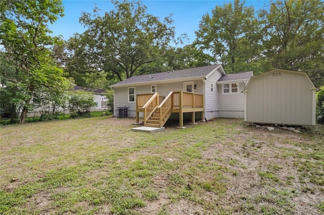 rear view of property featuring a wooden deck, a yard, and cooling unit